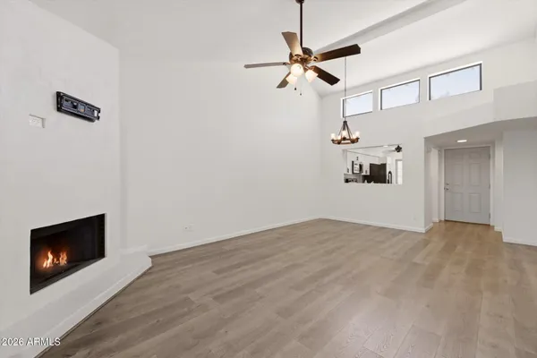 a view of an empty room with a window and wooden floor