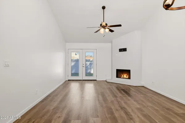 a view of a livingroom with a fireplace wooden floor and chandelier
