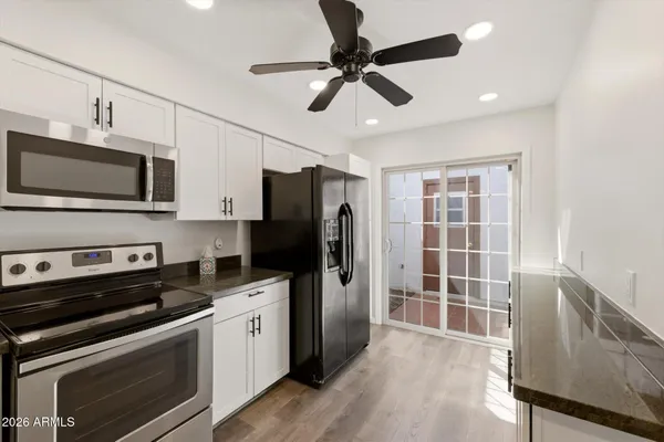 an empty room with windows and fan