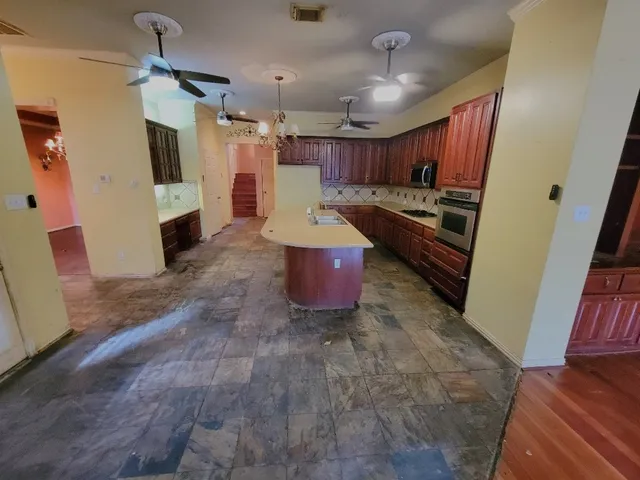 a large kitchen with a stove a refrigerator a oven with the cabinets