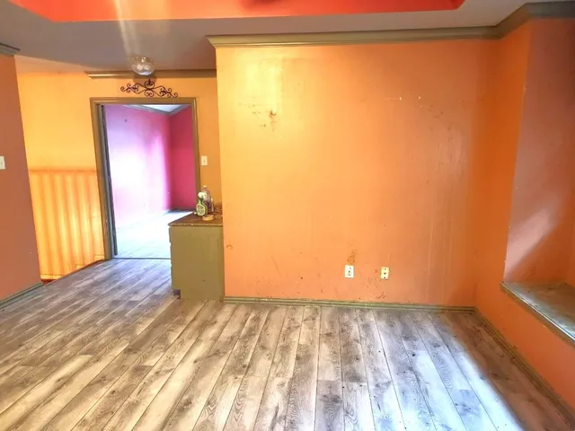 a view of a room with wooden floor and a window