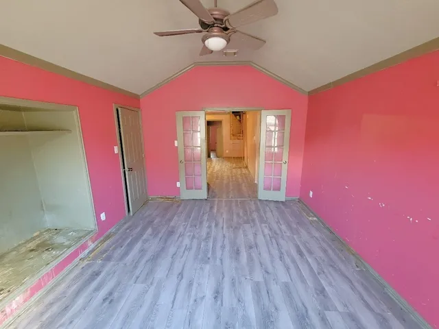 a view of a room with wooden floor and front door