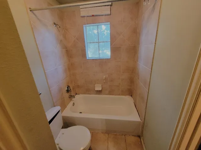a bathroom with a toilet and a tub