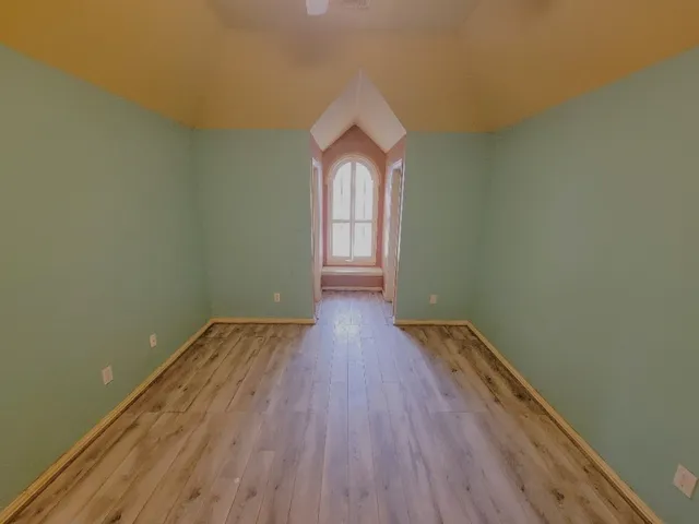 a view of a room with wooden floor and white walls