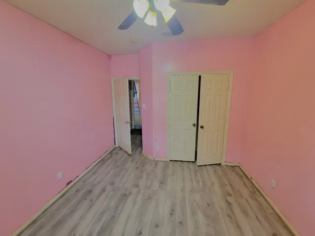 a view of a livingroom with wooden floor and a ceiling fan