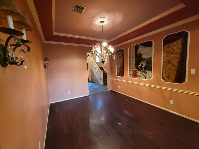 a view of a living room with chandelier and wooden floor