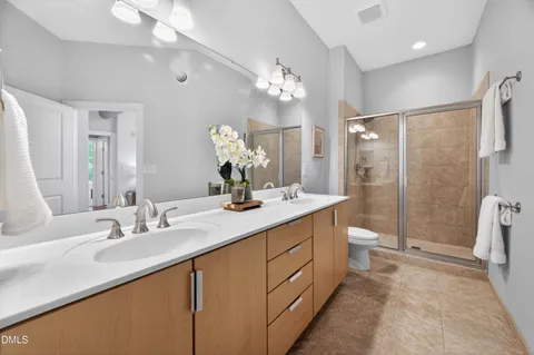 a bathroom with a double vanity sink mirror and toilet