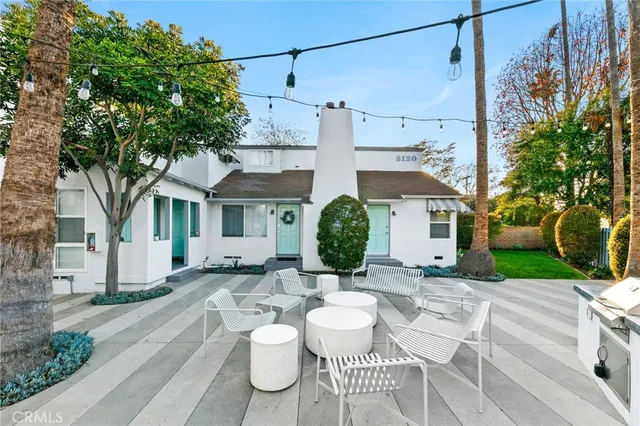 a view of a patio with couches table and chairs and potted plants