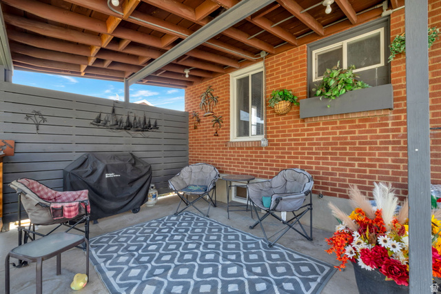 7391 Elm Street Midvale, UT 84047 - Photo 24 of 38 Covered patio area featuring a brick exterior wall and a slatted privacy fence. Great for entertaining guests in the heat. Totally covered.