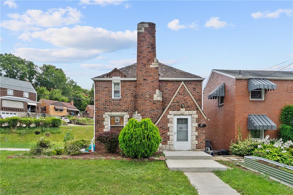 a front view of a house with a garden and plants