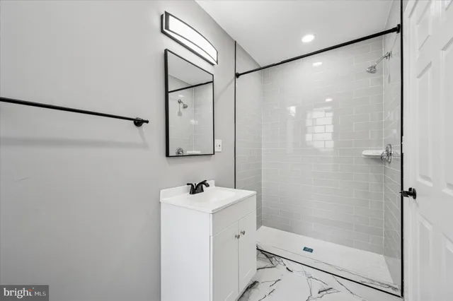 a bathroom with a shower sink and mirror