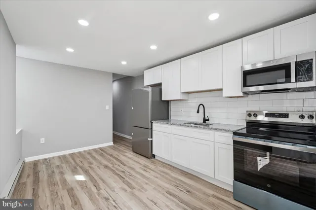 a kitchen with stainless steel appliances granite countertop a sink and a stove top oven