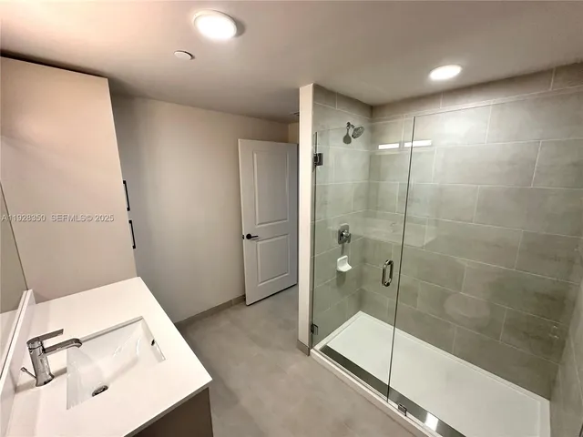 a bathroom with a tub a sink and a shower