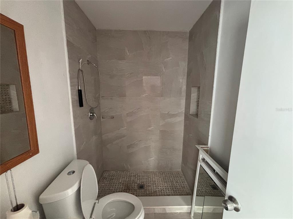 4061 55th Way North, Unit 1042 Kenneth City, FL 33709 - Photo 15 of 18 a bathroom with a shower and toilet