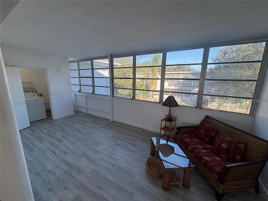 4061 55th Way North, Unit 1042 Kenneth City, FL 33709 - Photo 6 of 18 a living room with furniture and a large window