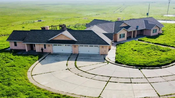 a aerial view of a house with a yard and lake view