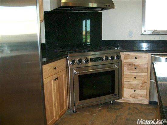 20552 Buchanan Hollow Road, Unit 1 Le Grand, CA 95333 - Photo 13 of 26 a stove top oven sitting inside of a kitchen