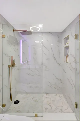 a view of a livingroom with wooden floor and a bathroom