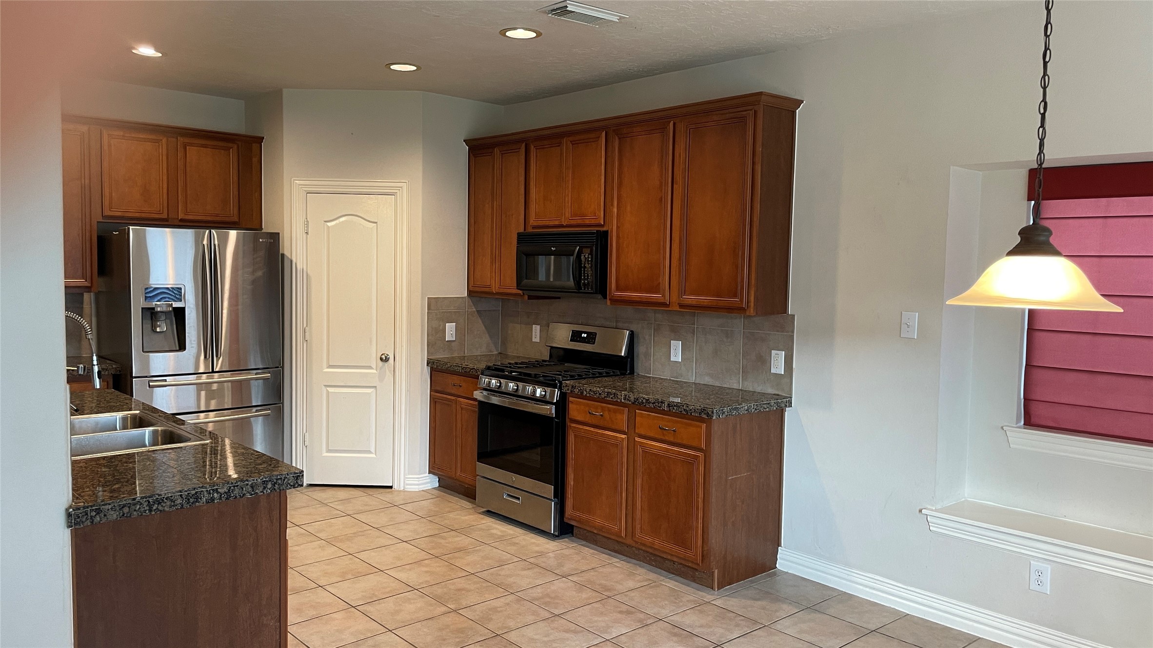 3518 Ewing Drive Manvel, TX 77578 - Photo 12 of 50 a kitchen with stainless steel appliances granite countertop a refrigerator stove and microwave