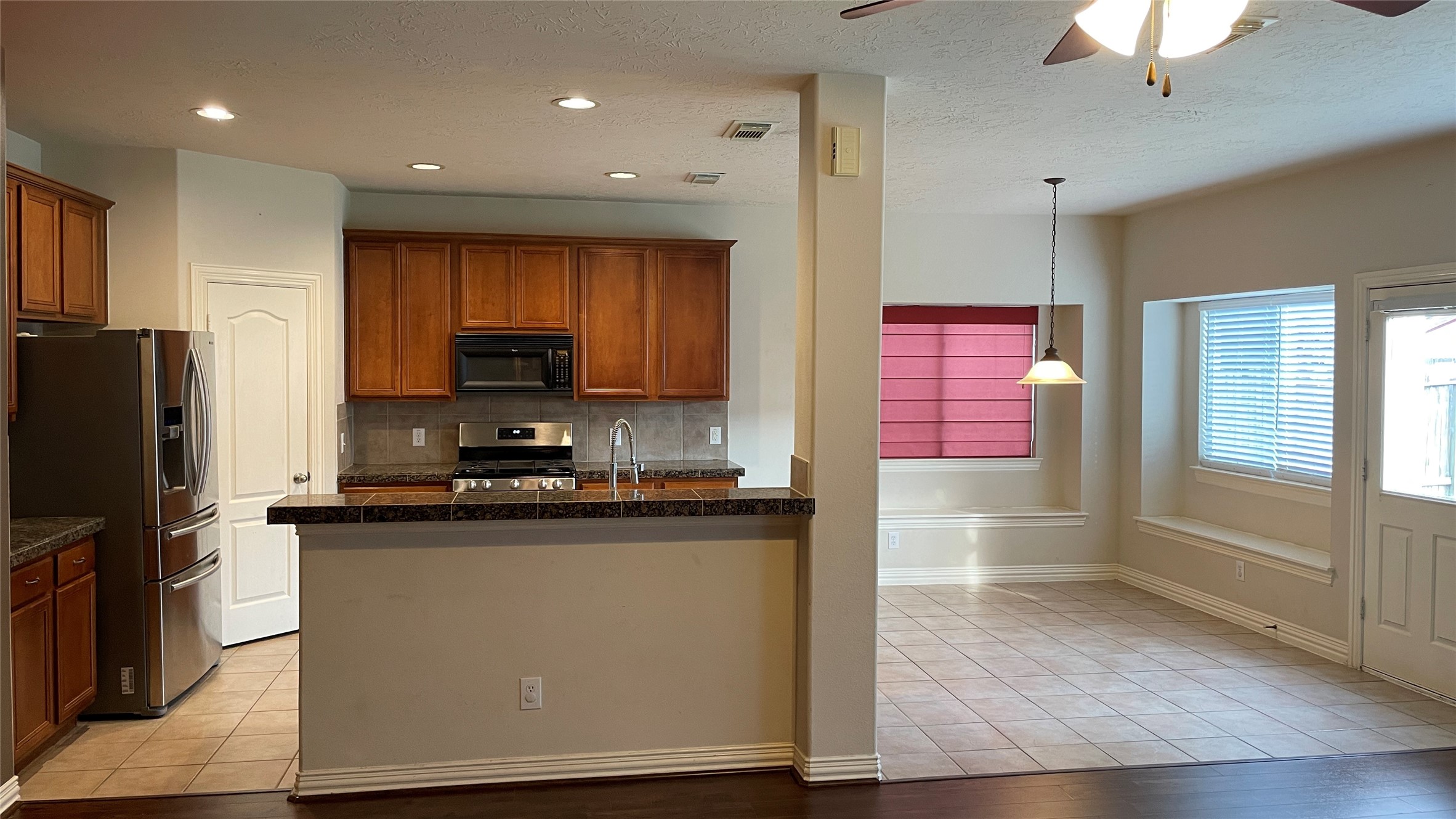 3518 Ewing Drive Manvel, TX 77578 - Photo 13 of 50 a kitchen with stainless steel appliances granite countertop a stove top oven a sink and a refrigerator