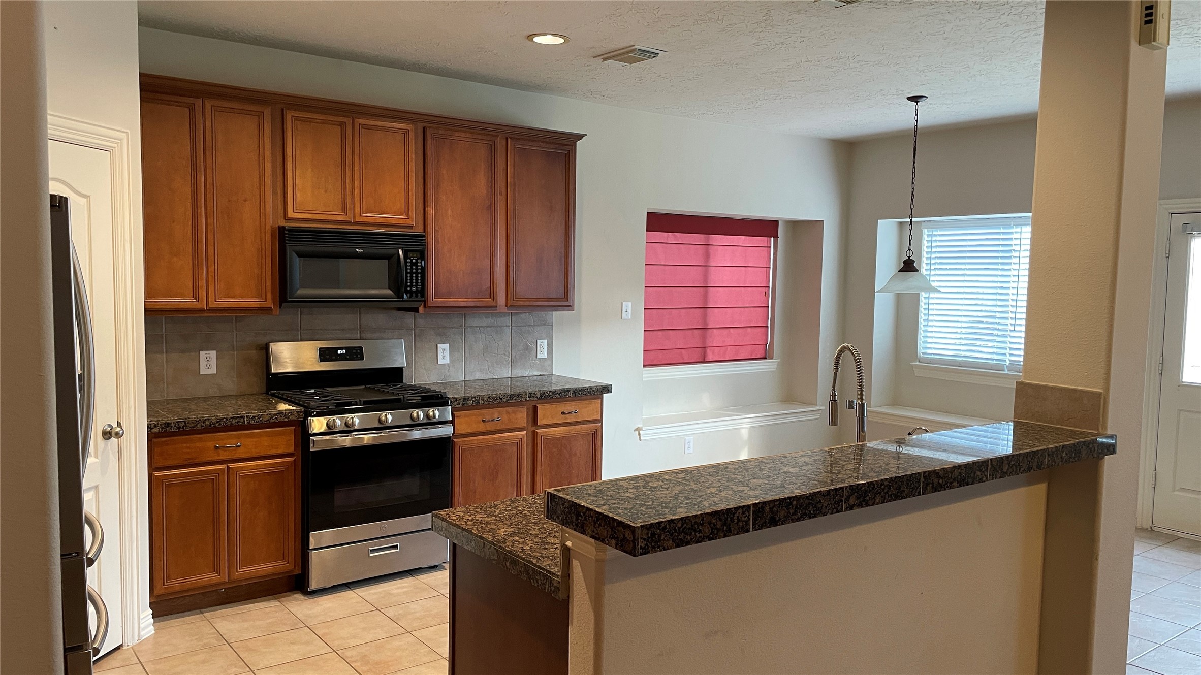 3518 Ewing Drive Manvel, TX 77578 - Photo 15 of 50 a kitchen with granite countertop a stove sink and microwave