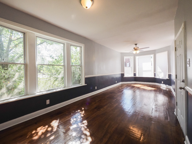 6849 South Green Street, Unit 1 Chicago, IL 60621 - Photo 2 of 7 a view of an empty room with wooden floor and a window
