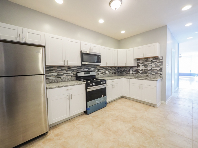 6849 South Green Street, Unit 1 Chicago, IL 60621 - Photo 3 of 7 a kitchen with stainless steel appliances granite countertop a refrigerator a stove a sink and a microwave