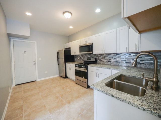 6849 South Green Street, Unit 1 Chicago, IL 60621 - Photo 4 of 7 a kitchen that has a sink and a stove top oven