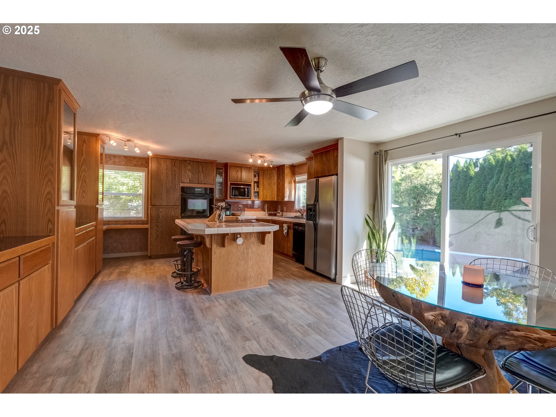1421 Southwest 6th Place Gresham, OR 97080 - Photo 13 of 27 a kitchen with stainless steel appliances kitchen island granite countertop a refrigerator a stove top oven a chimney wooden floor and furniture