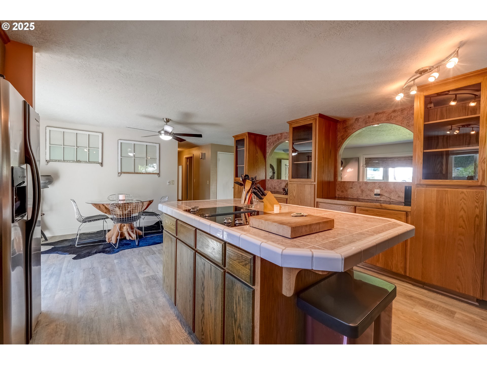 1421 Southwest 6th Place Gresham, OR 97080 - Photo 10 of 27 a kitchen with stainless steel appliances granite countertop a table chairs and a refrigerator