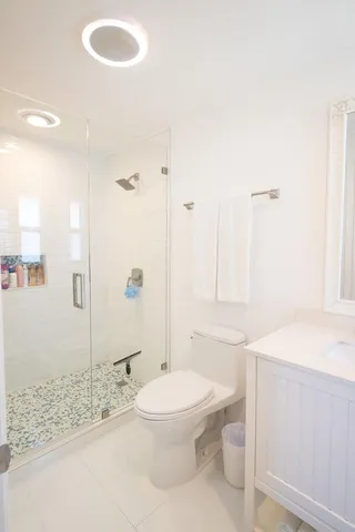 a bathroom with a sink a toilet and shower