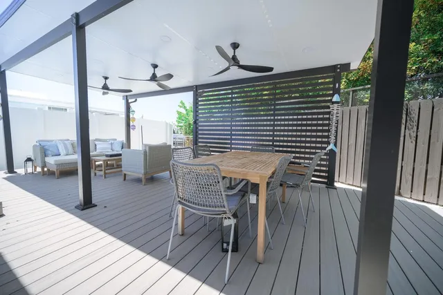 a view of a deck with table and chairs with wooden floor and floor to ceiling window