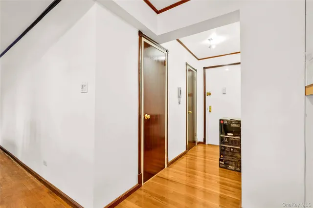 a view of a hallway with wooden floor and door