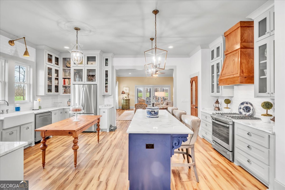 117 Pine Bough Trail Perry, GA 31069 - Photo 7 of 83 a large kitchen with kitchen island a stove a sink dishwasher a dining table and chairs with wooden floor