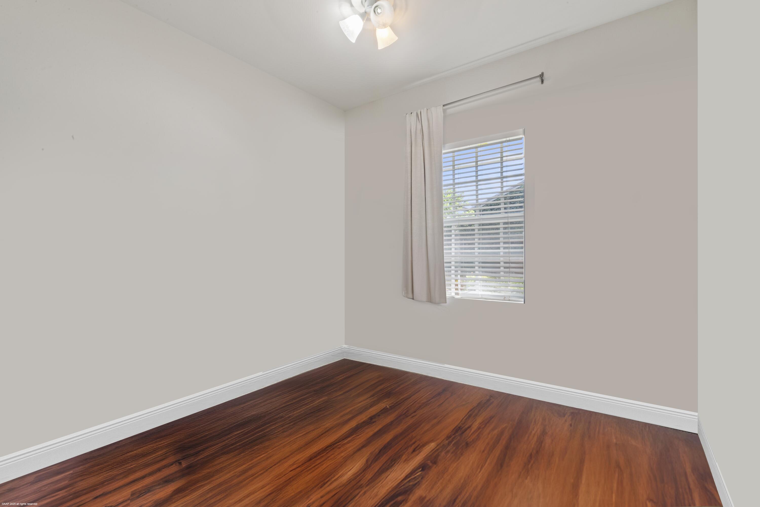 15527 Imperial Point Lane Wellington, FL 33414 - Photo 154 of 184 a view of an empty room with wooden floor and a window