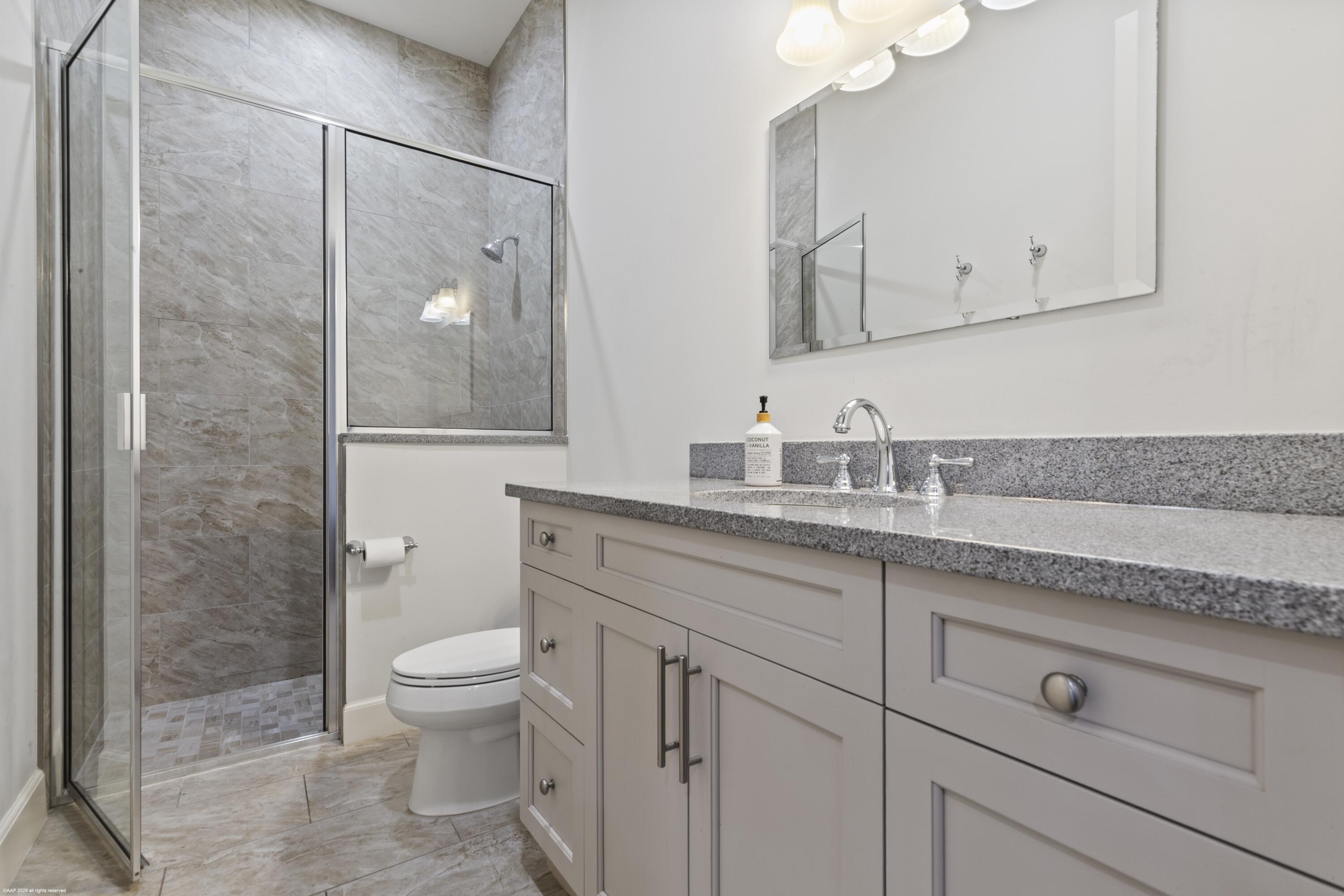 15527 Imperial Point Lane Wellington, FL 33414 - Photo 156 of 184 a bathroom with a granite countertop sink a toilet and a mirror