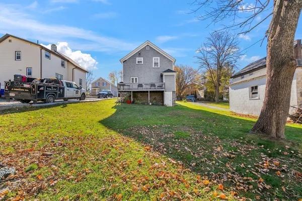a view of a house with a big yard and large trees