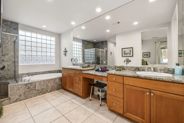 a bathroom with a granite countertop sink a large mirror and a shower