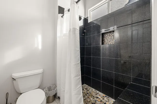 a view of a patio with table and chairs potted plants and large tree