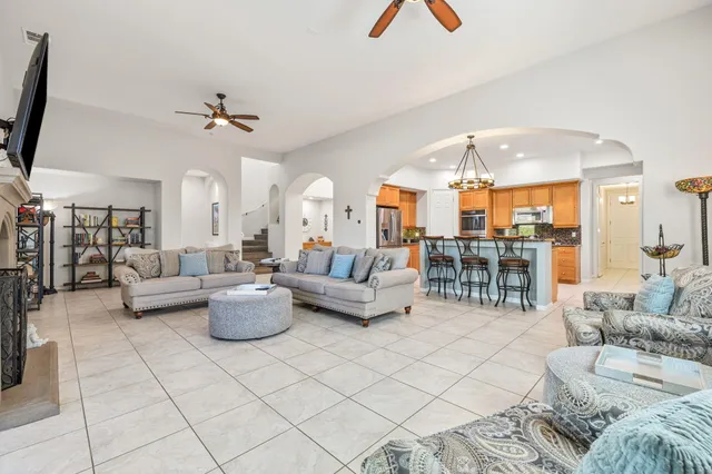 a living room with furniture a fireplace and a chandelier