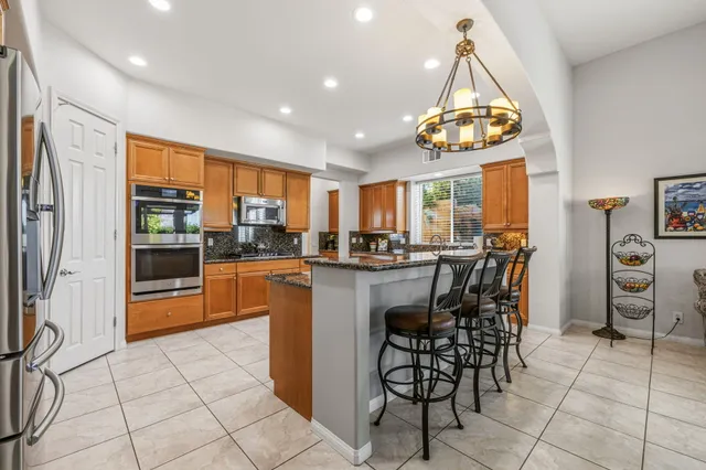 a kitchen with stainless steel appliances granite countertop a refrigerator and a sink