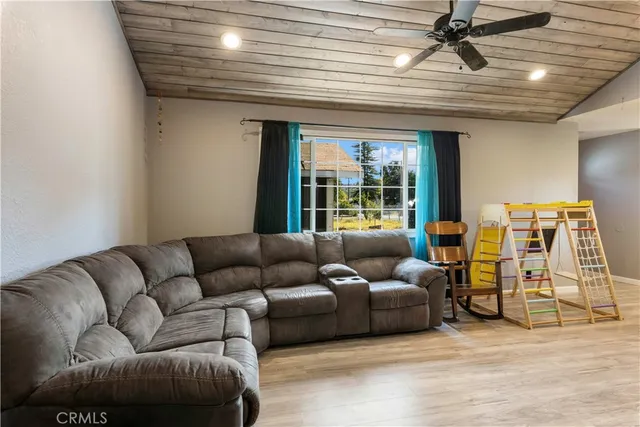 a view of an entryway with wooden floor and a flat screen tv