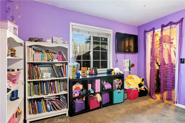 a bed sitting in a bedroom next to a window and a chandelier