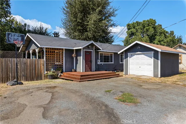 a view of a house with a yard and large tree
