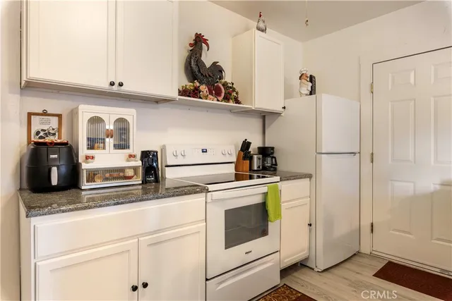 an aerial view of residential house with parking and trees