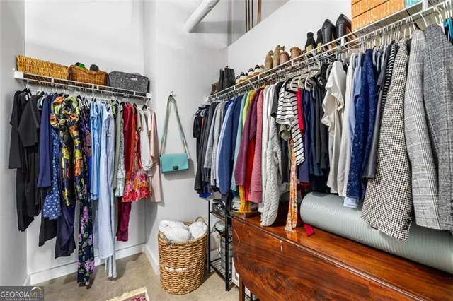 a view of walk in closet with clothes and shoes