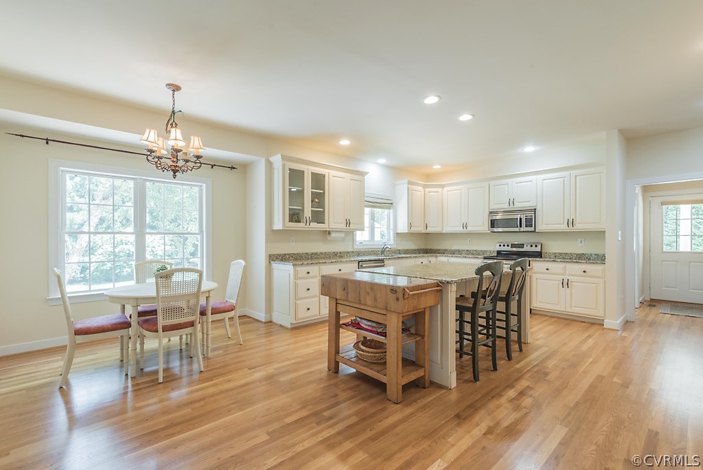 11710 Taplow Road Midlothian, VA 23112 - Photo 22 of 48 a kitchen with kitchen island granite countertop a dining table chairs and refrigerator