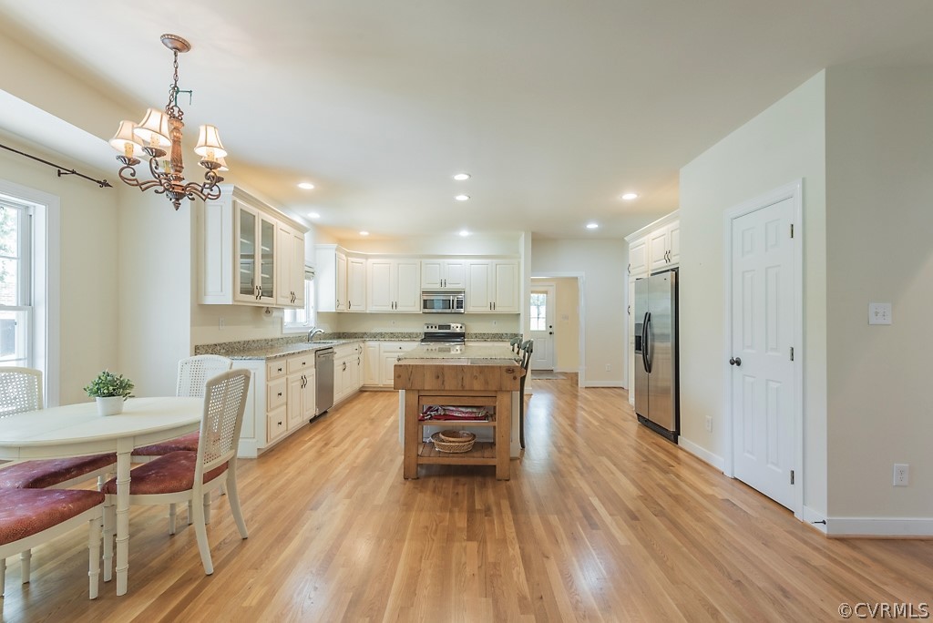 11710 Taplow Road Midlothian, VA 23112 - Photo 23 of 48 a open kitchen that has a lot of cabinets stainless steel appliances and a chandelier