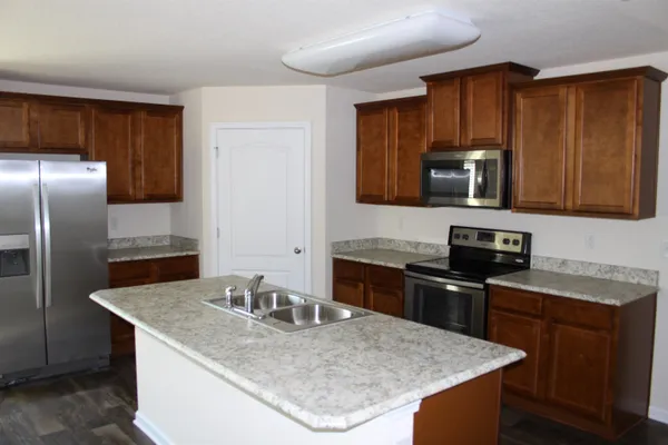 a kitchen with granite countertop a sink stove and refrigerator
