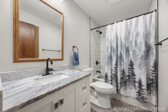 a bathroom with a granite countertop sink toilet and shower